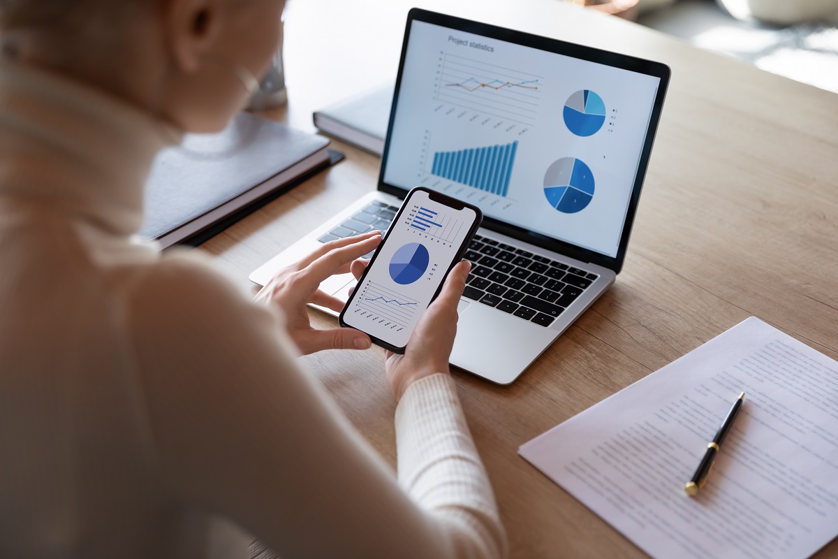 laptop and phone looking at charts